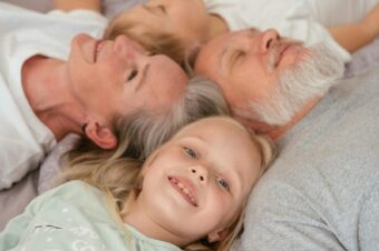 A joyful multigenerational family lying together and smiling, illustrating love and togetherness.